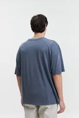 Remera de manga corta color verde con efecto lavado, corte boxy holgado con hombros caídos, escote redondo y logo bordado en el pecho.