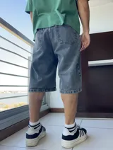 Bermuda de jean gris oscuro con lavado gastado, corte ancho y largo a la rodilla.