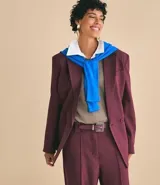 Blazer femenino color bordó, de corte oversized y caída recta. Presenta cierre traspasado con dos botones delanteros, mangas largas, cuello con solapa tradicional y bolsillos delanteros con acabado incorporado. Cuenta con forro interno.