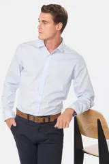 Camisa de vestir celeste entallada, de manga larga y cuello clásico.