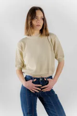 Sweater de punto color tostado con hilos metalizados, de corte recto, escote redondo y mangas cortas con puño ajustado.