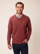 Sweater de punto con cuello en V, manga larga y puños acanalados. Presenta un pequeño logo bordado en el pecho.