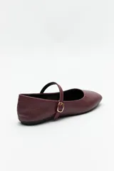 Balerinas color crudo de símil cuero texturizado, con punta redondeada, tira sobre el empeine y hebilla metálica ajustable.