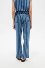 Pantalón de jean de corte recto y tiro bajo con diseño de rayas verticales en tonos azules y sutiles líneas rojas.