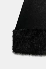 Vestido corto de punto color negro, con cuello redondo, manga corta y bajo con aplicación de pelo sintético a tono.