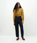 Pantalón de jean estilo carrot de tiro alto, color azul oscuro, con cierre frontal de cremallera y botón, bolsillos funcionales y corte cónico en las piernas.