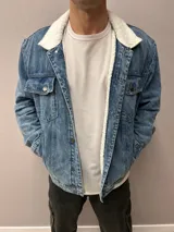 Chaqueta de jean azul con cuello y forro de corderito blanco.