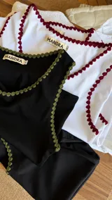 Musculosa de morley verde militar con escote redondo y detalles de bordado artesanal en crochet en los bordes.
