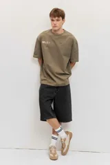 Remera oversize verde militar con pequeño estampado frontal en el pecho.