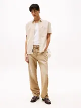 Camisa de corte regular confeccionada en puro algodón mil rayas con una sutil textura. Diseño integral de rayas verticales, cuello con botones, bolsillo de parche en el pecho, detalles distintivos de Tommy Jeans y parche con el logo de Tommy Jeans en el bolsillo.