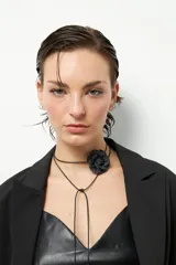 Top negro de símil cuero, sin mangas, con escote en V, pinzas y corte en la cintura. Cierre metálico en la espalda.