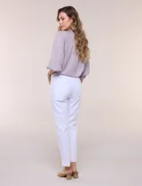 Pantalón ankle de tiro alto color blanco, confeccionado en tejido elástico con pretina ancha tipo pull-on, corte entallado y detalle de encaje calado en las aberturas laterales del ruedo.