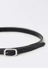 Cinturón fino de cuero vacuno en color negro, con hebilla metálica rectangular de diseño minimalista.