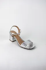 Sandalias de fiesta metalizadas color celeste, con taco cuadrado de 4 cm, tiras delanteras acolchadas y tira ajustable al tobillo con hebilla dorada.