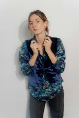 Chaleco de corte sastrero confeccionado en tejido velour, con escote en V y cierre frontal mediante botones al tono.