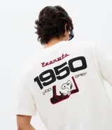 Remera de algodón de manga corta y cuello redondo, con diseño de estilo automovilístico. Presenta una estampa frontal con el personaje Snoopy, el logo de Peanuts Motorsport y la inscripción Racing Team.