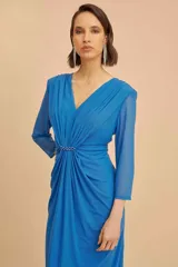 Vestido midi de fiesta confeccionado en microtul color azul, con escote en V y mangas 3/4. Presenta drapeados frontales y detalles de perlas a tono en la cintura.