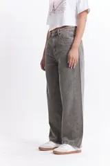 Pantalón jean gris de tiro medio, corte amplio y redondeado.