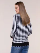 Cardigan de silueta recta confeccionado a rayas horizontales en contraste de negro y blanco, con detalles de calados sutiles y terminaciones onduladas. Cuenta con escote redondo clásico, cartera frontal completa con botones a tono, y mangas largas finalizadas en puños anchos con borde ondulado.