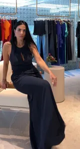 Mono largo azul marino, sin mangas, con escote halter y abertura en el pecho. El pantalón es de corte ancho y fluido.