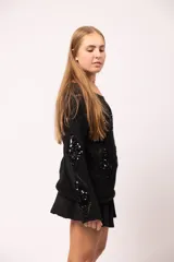 Buzo negro de tejido de punto con diseño calado de rombos y apliques de lentejuelas negras en el frente y las mangas.