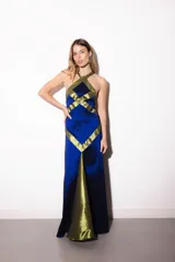 Vestido largo de tafeta azul con detalles de recortes geométricos en contraste de color verde militar, con diseño halter cruzado y silueta ajustada al cuerpo.
