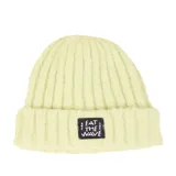 Gorro tipo beanie de lana tejido en canalé, color verde claro, con parche rectangular negro frontal que incluye la frase 'EAT THE WAVE' bordada en blanco.