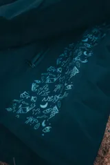 Campera negra con capucha y cierre frontal, con interior acolchado y diseño estampado en la manga.