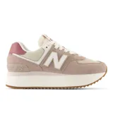 Championes urbanos New Balance modelo 574, color rosa claro con detalles en beige, blanco y burdeos, confeccionados en gamuza y malla, con logo "N" característico en los laterales y entresuela alta de plataforma.