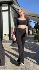 Calza negra acampanada con aberturas laterales y bolsillo interno en la cintura.