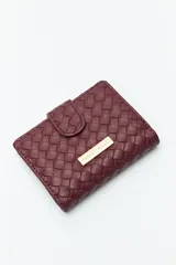 Billetera de mujer Daniel Cassin con diseño trenzado, cierre con broche a presión y placa metálica dorada con el logo de la marca en el frente.