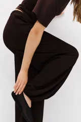 Pantalón globo de corte holgado en punto con textura, color marrón oscuro, con cintura elástica y bajos elásticos.