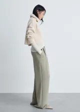Pantalón wide leg de tiro medio con cintura elástica y cordón ajustable. Presenta diseño con pinzas frontales, bolsillos laterales y corte holgado.