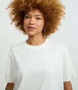 Remera boxy de manga corta y cuello redondo, confeccionada en algodón liso negro de corte holgado.