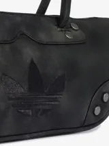 Bolso de hombro estilo bowling de Adidas, color negro con efecto desgastado, asas largas, detalles de remaches metálicos y el logo del Trifolio grabado en el frente.