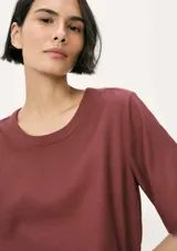 Blusa de manga corta con cuello redondo, confeccionada en tejido de lino con textura natural, de corte recto y ajuste cómodo.