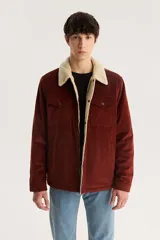 Campera marrón de pana con cuello y forro de sherpa color crema, cierre frontal con cremallera y bolsillos con solapa abotonada en el pecho.