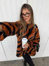 Buzo de peluche con estampado animal print de leopardo, de corte oversize, cuello redondo y mangas largas.