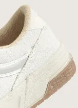 Championes Vans Hylane Vintage, color blanco con suela de goma marrón, diseño robusto de inspiración retro con la icónica franja lateral y cordones anchos.