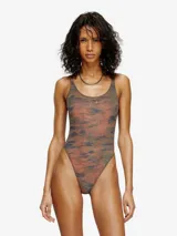 Traje de baño enterizo con diseño de camuflaje en tonos verdes y marrones. Presenta un corte cavado, escote redondo y un detalle metálico con el logo de la marca en el centro del pecho.