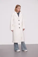 Tapado largo color marfil de poliéster con solapas, cierre con botones y corte holgado.