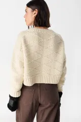 Sweater crop de tejido de punto con diseño de rombos en relieve, cuello redondo y terminaciones acanaladas en puños y ruedo.