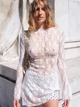 Vestido corto confeccionado en encaje con diseño de mangas largas acampanadas y corte ajustado.