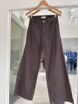 Pantalón de jean color marrón tabaco, de corte recto y pierna ancha, con tajo lateral en el ruedo.