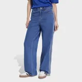 Pantalón de jean Adidas modelo Firebird, de corte recto y tiro medio. Presenta las icónicas tres franjas laterales en color blanco y cierre frontal con botón y cremallera.
