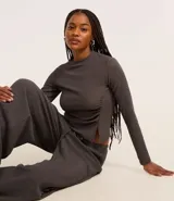 Blusa gris oscuro texturizada de poliéster y elastano, con cuello alto, mangas largas y detalle de fruncido lateral.