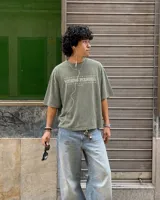 Remera marrón oversize de manga corta con estampado gráfico en la espalda de dos gatos de estilo retro con cuchillos y texto "Kahoa Industries".