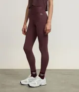 Legging deportiva ajustada al cuerpo, color morado oscuro, con cintura alta y bolsillo pequeño en la espalda.