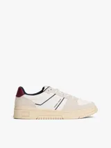 Zapatillas de corte bajo Tommy Jeans, confeccionadas en una combinación de cuero y ante en tonos blanco, beige y burdeos. Presentan suela cupsole de goma en color crema, cordones moteados y el logo de la marca en el lateral.