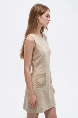 Vestido corto blanco de viscosa, sin mangas, con cuello redondo a la base y bolsillos frontales con apliques bordados.